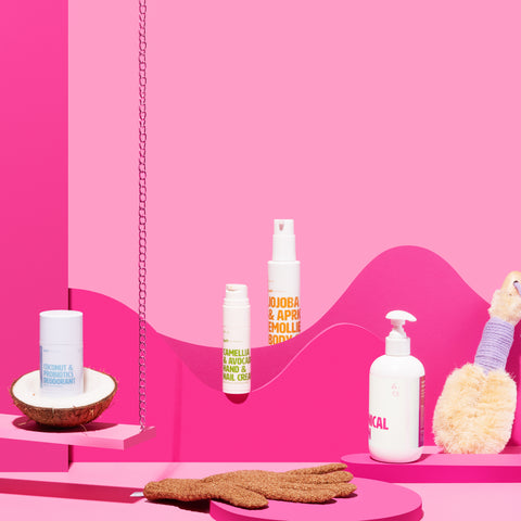 Coconut & Probiotics Deodorant in coconut on a pink swing plus various bodycare products strewn around pink props